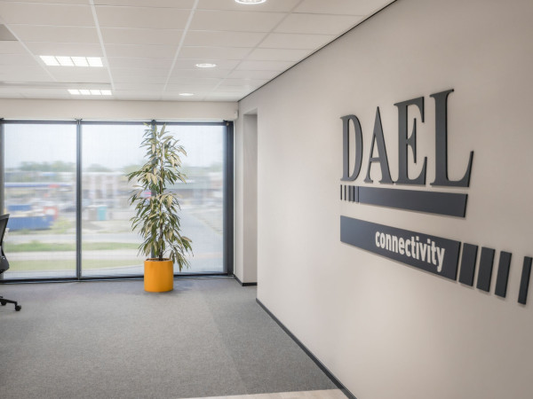 Kantoor van DAEL Connectivity met donkere rolgordijnen die het binnenvallende daglicht filteren.