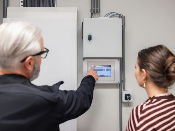 Vertegenwoordiger geeft uitleg over de centrale bediening van de elektrische zonwering bij Little Dutch.